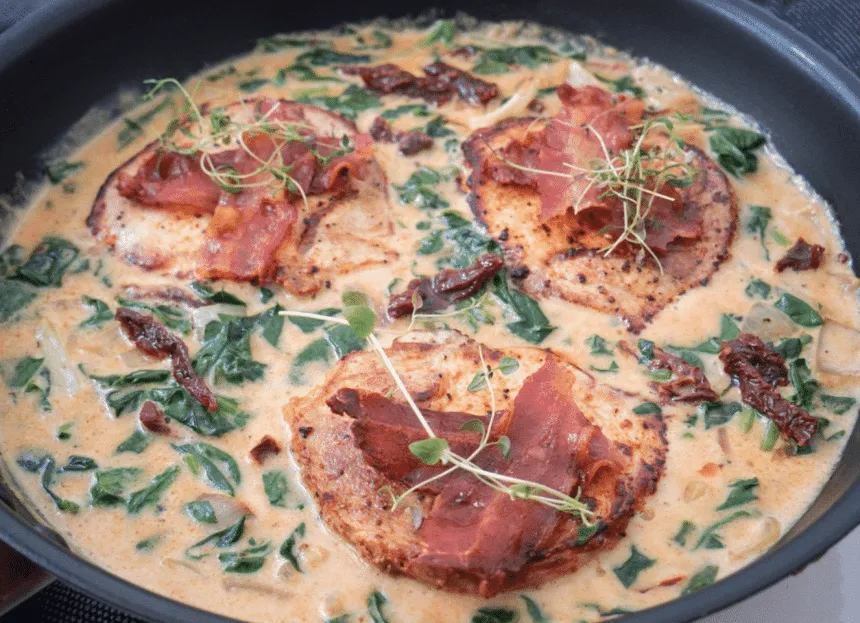 Koteletter i cremet sauce med spinat og soltørrede tomater