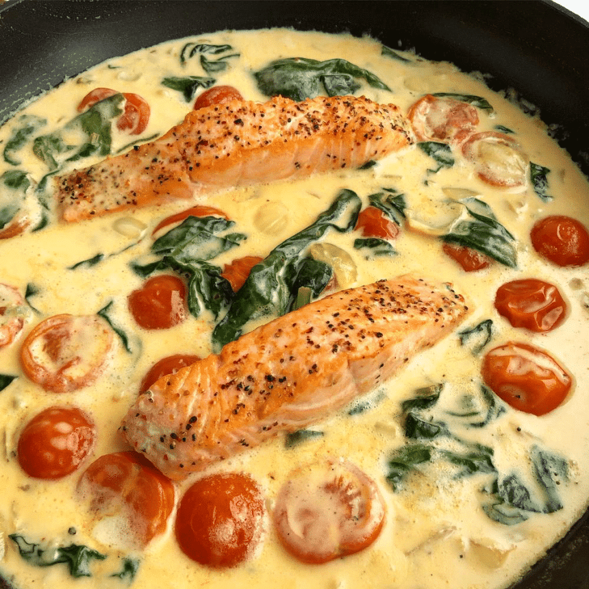 Laks i cremet sauce med tomater og spinat