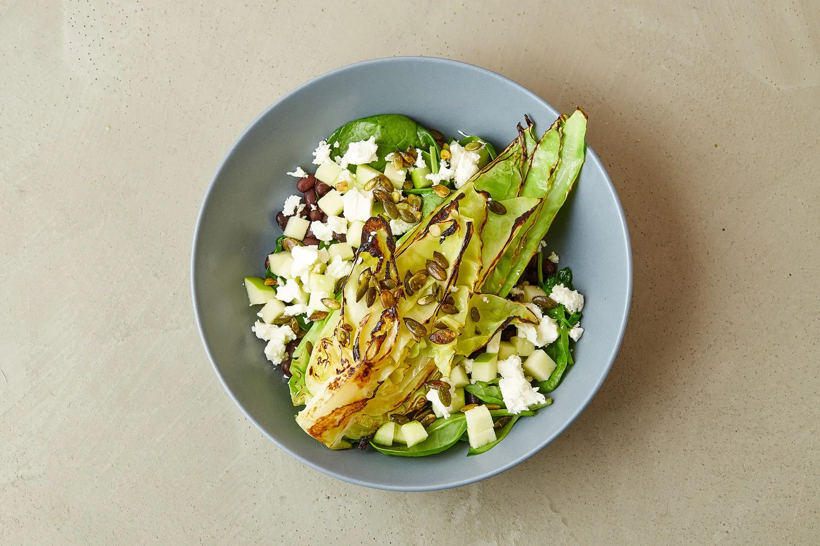 Stegt spidskål på sorte bønner med bladbeder og feta