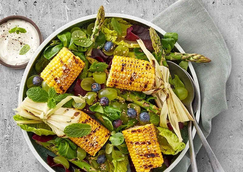 Frisk salat med grønne asparges, blåbær, grillet majs og grønne druer